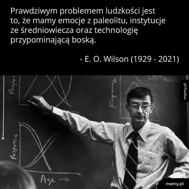 Mężczyzna przy tablicy z wykresami, cytat E. O. Wilsona.