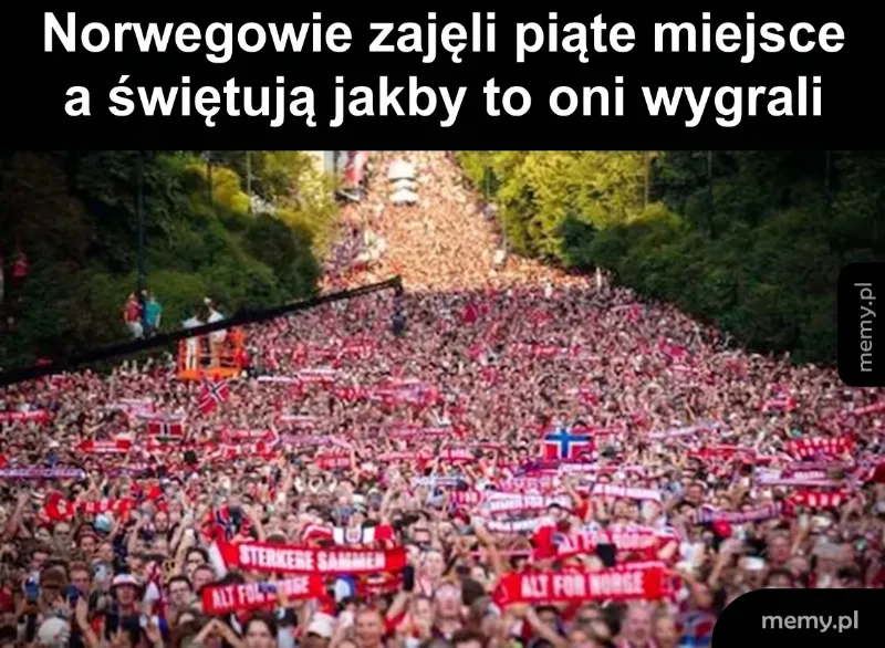 Tłum ludzi na stadionie z flagami i transparentami.