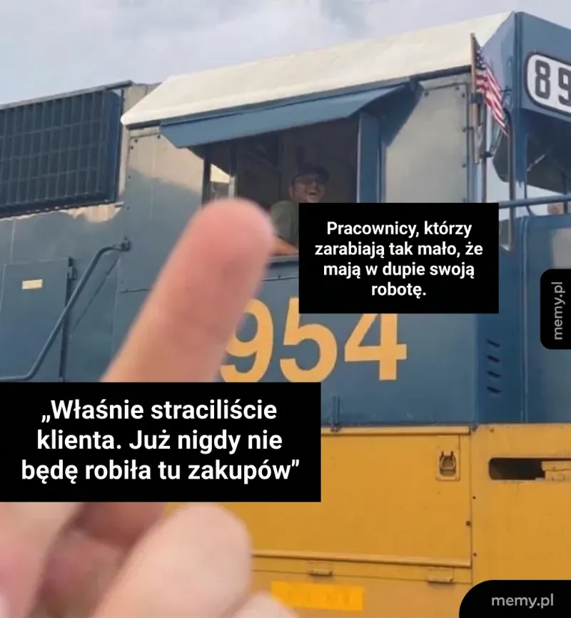 Mężczyzna w kabinie lokomotywy z uniesionym palcem wskazującym.
