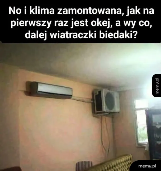 Klimatyzator zamontowany na ścianie, obok okno z kratką wentylacyjną.