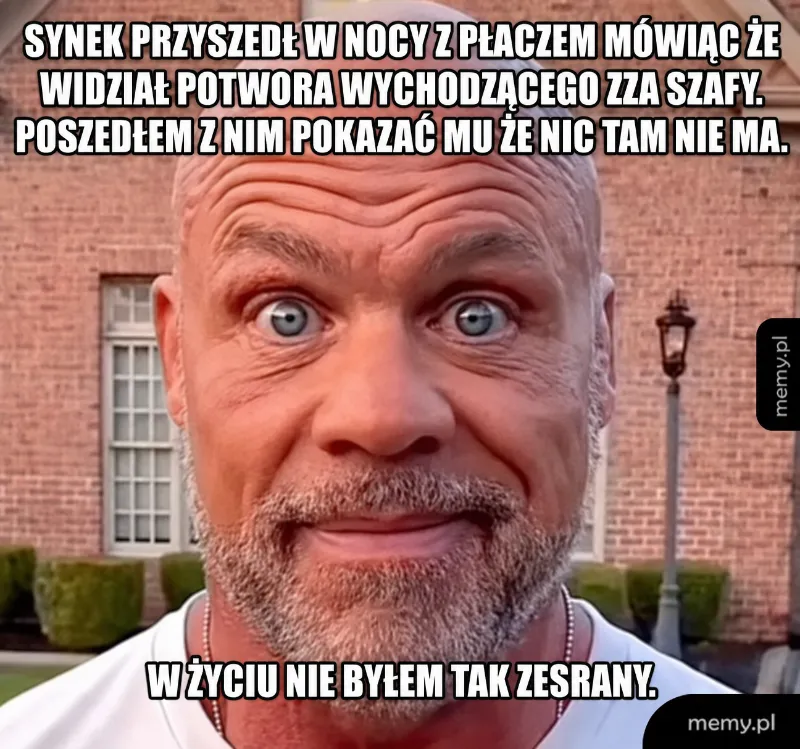 Mężczyzna z wyrazem zdziwienia na tle budynku.