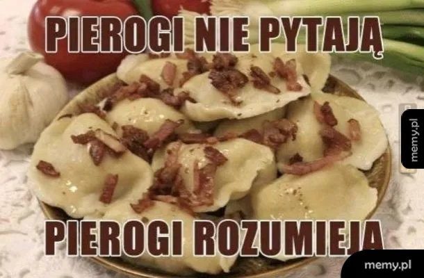 Talerz pierogów z boczkiem na tle warzyw.