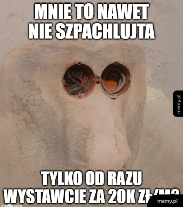 Obiekt z dwoma oknami przypominającymi oczy, z tekstem na górze i na dole.