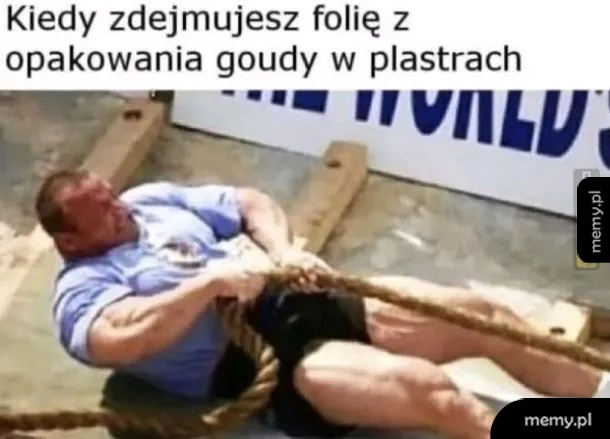 Mężczyzna ciągnący linę, z wyrazem wysiłku na twarzy.